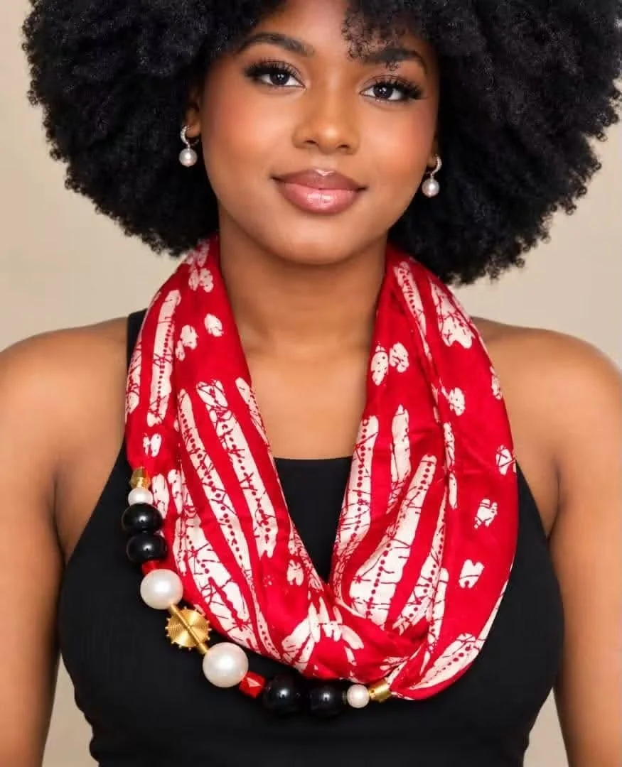Écharpe rouge et blanche portée avec un collier de perles